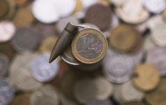 Image of a euro coin and a bullet side-by-side.