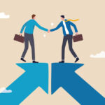 Two people stand on converging arrows and shake hands.
