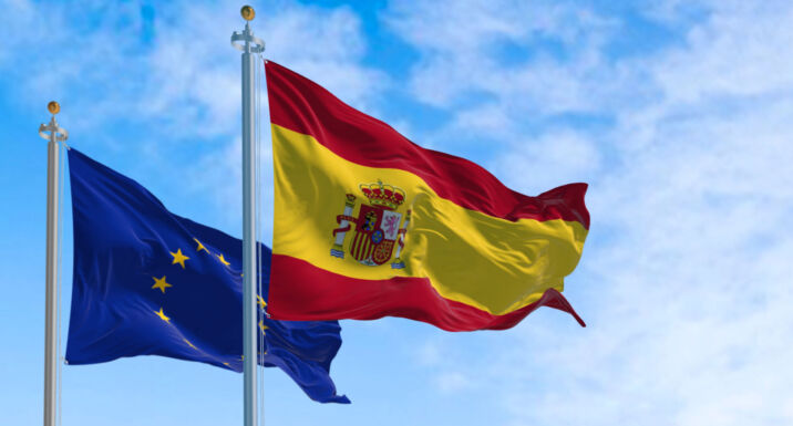 The flags of Spain and the European Union waving in the wind on a sunny day. Democracy and politics. European country.