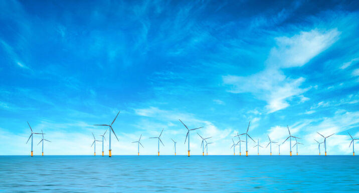 Offshore Wind Turbine in a Windfarm under construction off the England Coast at blue sky