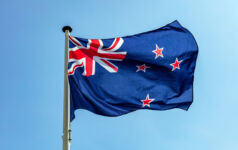 NZ Super updates human rights policy after losing lawsuit New Zealand flag, New Zealand national symbol waving against clear blue sky, sunny day