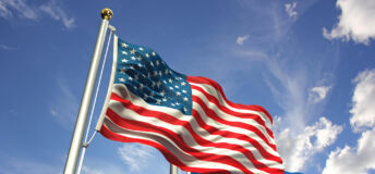 American and European Union flags waving against the sky.