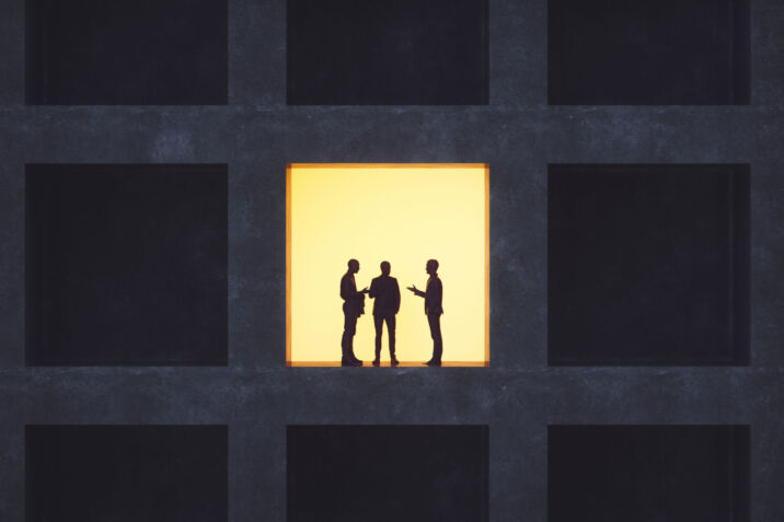 Businessmen talking in secrecy.