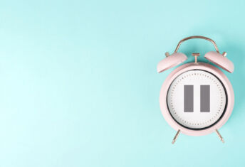 Alarm clock with pause sign, take a break, menopause concept, hormone replacement therapy