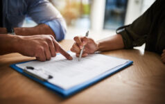 Cropped shot of a man and woman completing paperwork together at a desk