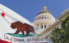 Photo of a faded California state flag laid over the California Capitol.