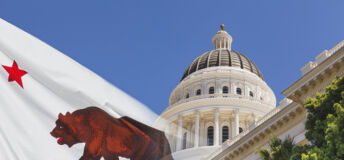 Photo of a faded California state flag laid over the California Capitol.