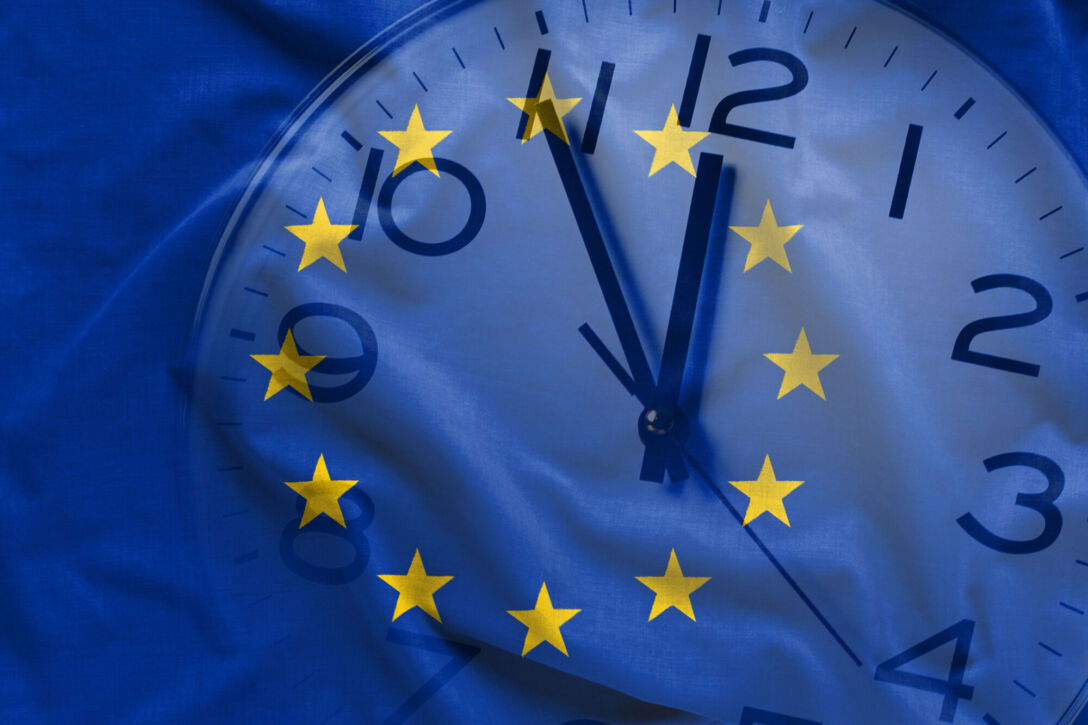 Double exposure of clock and blue flag of European Union