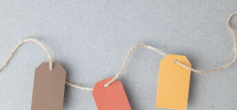 Autumn color palette, blank gift tags with jute twine string on a gray textured surface with copy space.