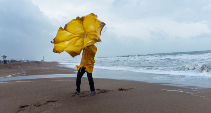 Physical climate risk data: The more you learn, the less you know Person on a beach trying to hold an umbrella on a windy day