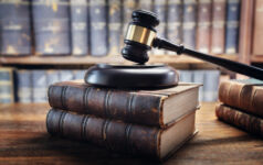 US firms sued by investors over shareholder proposal omissions Judge gavel and law books in court, law and justice background concept