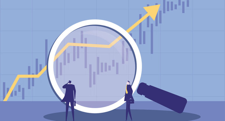 Two businessmen using a magnifying glass to observe market trends.