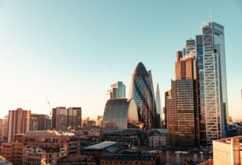 Wide angle of sun setting over London Gherkin.