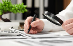 Businessman working in office and calculating finance. Using magnifying glass. Business financial accounting concept.
