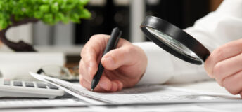 Businessman working in office and calculating finance. Using magnifying glass. Business financial accounting concept.