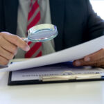 ClientEarth goes after UK LGPS fund over scenario analysis Lawyer or judge use magnifier glass look to the paper for inspection examination to the law case