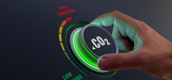 Hand turning dial marked CO2 to "low emissions"