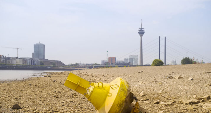 German investors engage firms on Rhine low water levels Low stream gauge of rhine river.Water shortage, drought, climate change,global warming concept, dry river bed with skyline of the town of dรผsseldorf, germany in the background