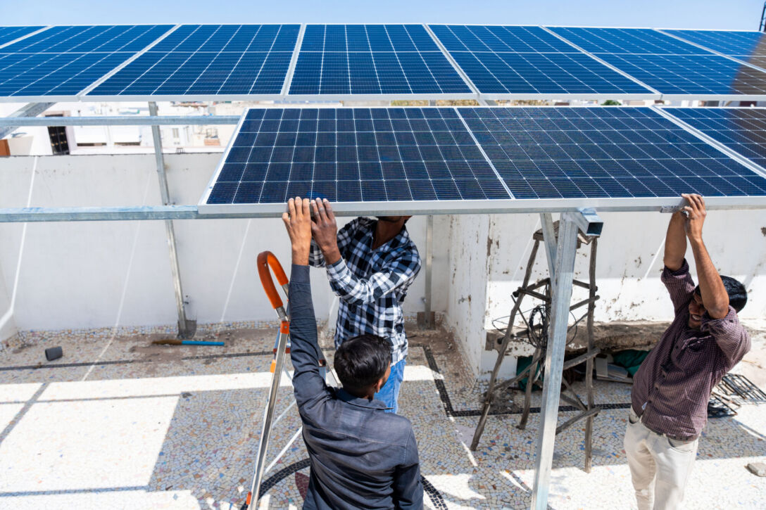 Indian workers installing solar panels on roof of house. Maintenance of photovoltaic panel system. Concept of alternative, renewable energy. Getty, Indian workers installing solar panels on roof of house.